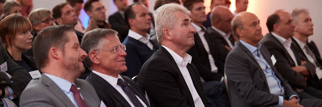 Landrat Hans-Jürgen Petrauschke und Minister Pinkwart sitzen im Publikum