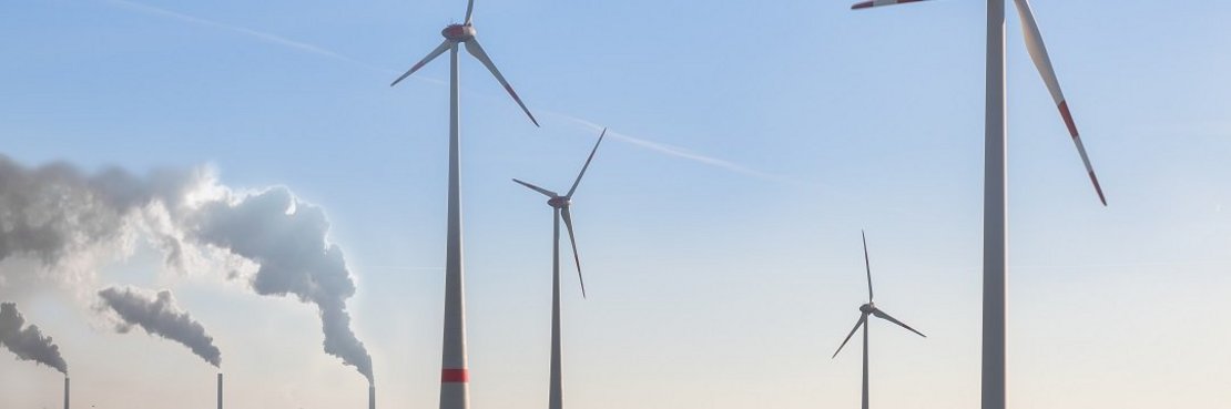 Windräder und Kraftwerke aufgenommen in der Landschaft.