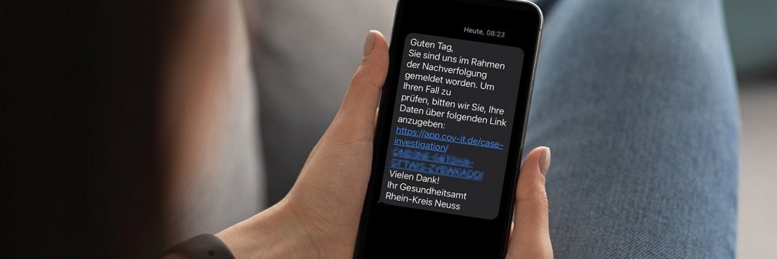 Eine Person ließt eine SMS am Smartphone.