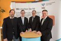 Landrat Hans-Jürgen Petrauschke, Norbert Kothen und Wolfgang Wappenschmidt und Raimund Franzen vor einer Stellwand an einem Stehtisch