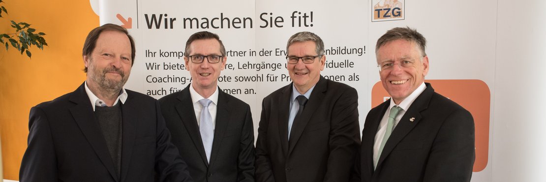 Landrat Hans-Jürgen Petrauschke, Norbert Kothen und Wolfgang Wappenschmidt und Raimund Franzen vor einer Stellwand an einem Stehtisch