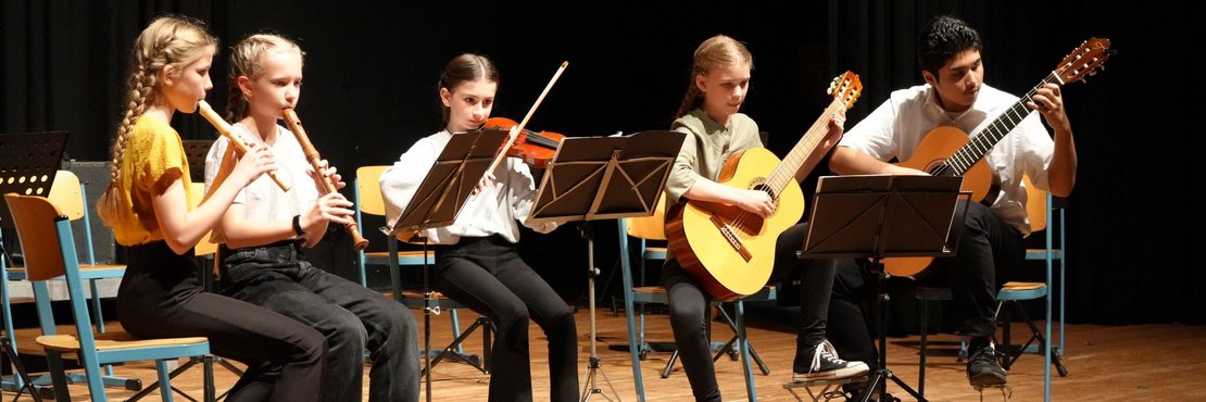 Fünf Kinder mit Instrumenten auf einer Bühne