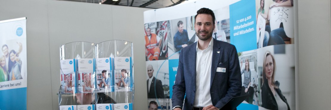 Männliche Person an einem Messestand