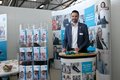 Männliche Person an einem Messestand