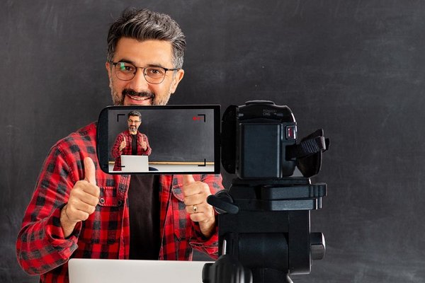 Lehrer wird gefilmt vor Tafel mit Laptop