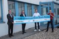 Die genannten Personen stehen vor einem Gebäude. In Ihren Händen halten sie gemeinsam ein langes Banner. Auf diesem steht geschrieben: CORONA-Testzentrum Rhein-Kreis Neuss; Standaort Neuss, Logos sind zu sehen: Rhein-Kreis Neuss, Kassenärztliche Vereinigung Nordrhein und Deutsches Rotes Kreuz