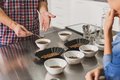 Eine Person zeigt einer anderen verschiedene Kaffeesorten, die in Schalen gefüllt sind