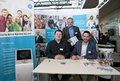 Drei Personen an einem Messestand