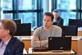 Christian Böhme sitzt mit Laptop an einem Tisch und spricht in ein Mikrophon.