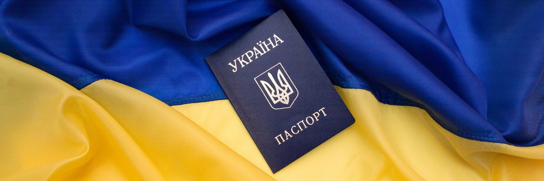 Symbolbild: Ukrainischer Pass auf ukrainischer Flagge
