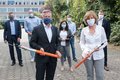 Landrat Hans-Jürgen Petrauschke und Bürgermeisterin Angelika Mielke-Westerlage stehen mit anderen Personen vor dem Mataré-Gymnasium und halten moderne Breitbandkabel in Ihren Händen. Alle tragen einen Mund-Nasenschutz