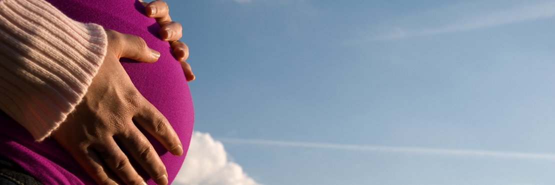 Eine Frau streichelt ihren Schwangerschaftsbauch