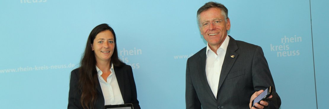 Landrat Hans-Jürgen Petrauschke und Barbara Edelhagen halten ein Smartphone und ein Tablet in ihren Händen