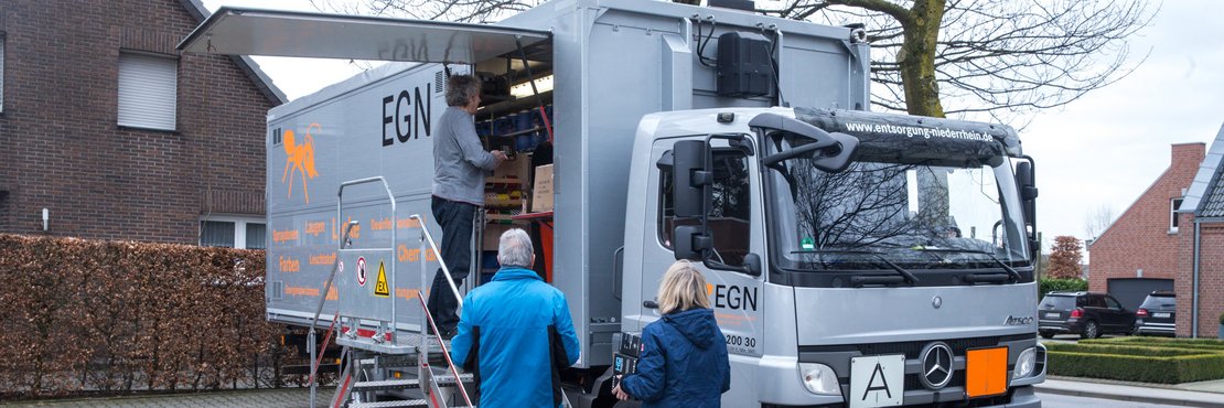 Vor einem LKW stehen drei Personen