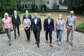 Landrat Hans-Jürgen Petrauschke steht mit Ursula Heinrichs, Thomas Dückers, Gregor Küpper, Natalia Jefimenko, Dr. Martin Mertens, Ulrike Schmitz-Doering und Harald Zillikens vor dem Kreisjugendamt. Alle tragen einen Mund-Nasenschutz. 