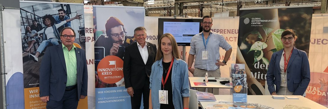 Robert Abts, Landrat Hans-Jürgen Petrauschke, Madita Beeckmann sowie Sebastian Gronwald und Dr. Marie Hurtgen vor dem Messestand