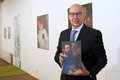 Tillmann Lonnes hält einen Ausstellungskatalog