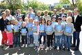 Präsidentin Beate Pricking (links), Landrat Hans-Jürgen Petrauschke (hinten links), und Stephan Meiser (hinten 2.v.l.) von der Sparkasse Neuss mit einer Gruppe von Kindern, die ein Heft in den Händen halten.