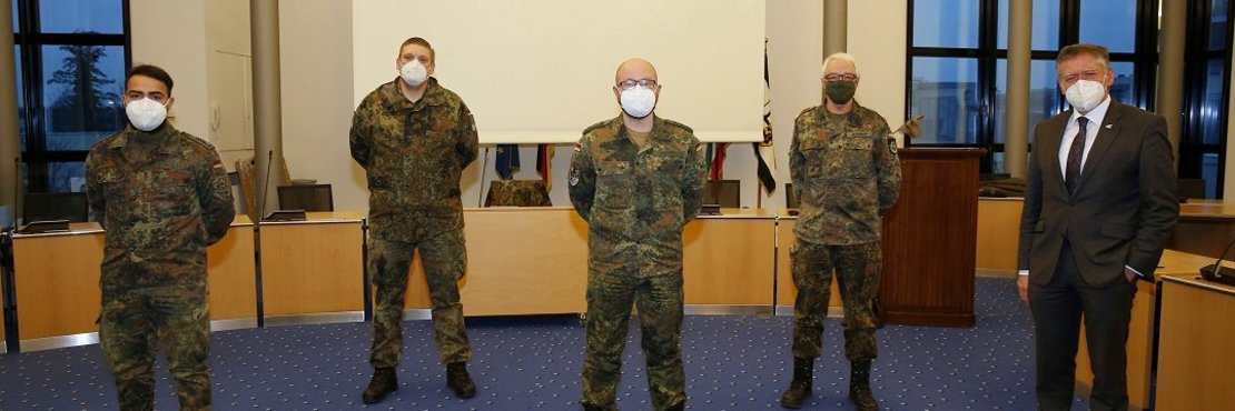 Landrat Hans-Jürgen Petrauschke zusammen mit vier Soldaten