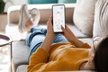Ein Mensch auf der Couch mit Smartphone in der Hand