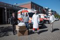 Landrat Hans-Jürgen Petrauschke und Kreisdirektor Dirk Brügge mit dem Leiter der Rettungswache Neuss Mitte Heiko Kraus und Thorsten Holz mit Kartons vor einem Rettungswagen