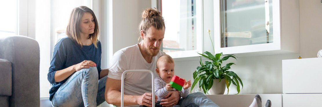 Junge Familie spielend in einem Wohnzimmer