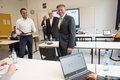 Christopher Drews und Elke Klehm mit Tillmann Lonnes und Landrat Hans-Jürgen Petrauschke stehen mit Abstand in einem Klassenzimmer mit Laptop und großem Bildschirm im Hintergrund