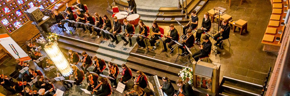 Orchester von oben fotografiert. In einer Kirche.