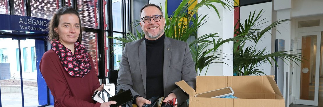 Yvonne Janssen und Harald Vieten mit Kisten voller alter Handys