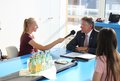 Schülerinnen mit Mikrophon und Kopfhörer interviewen eine männliche Person