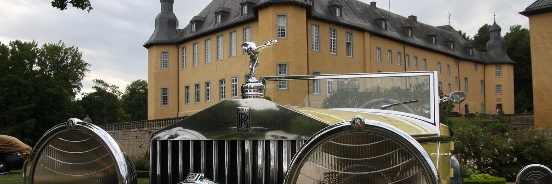 Oldtimer vor einem Schloss