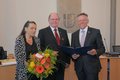 Landrat Hans-Jürgen Petrauschke steht mit Theo Thissen und Gattin Heidi (mit Blumenstrauß) im Kreissitzungssaal in Grevenbroich