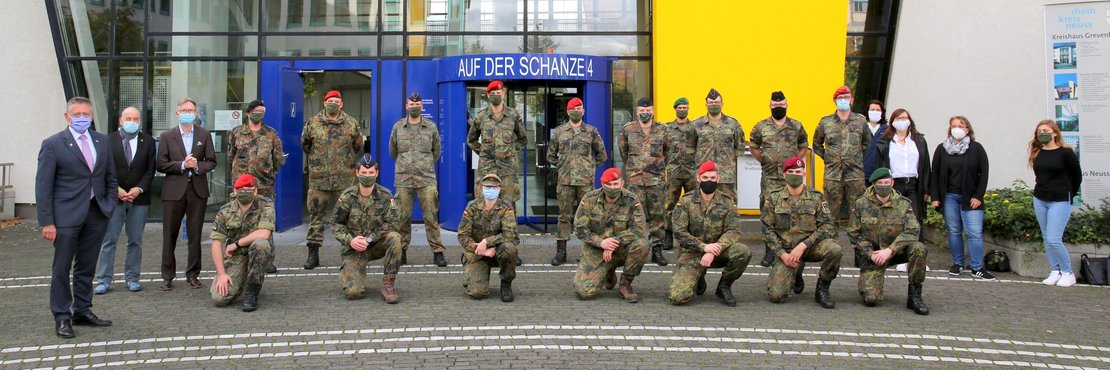 Landrat Petrauschke steht mit einer Gruppe Soldaten in Uniform vor dem Kreishaus