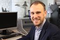 Johannes Feser lächelnd an einem Schreibtisch