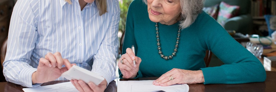 dekorativ, Frau hilft Seniorin bei ausfüllöen von Unterlagen
