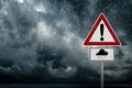 Dunkle Gewitterwolken mit einem Gefahrenzeichen