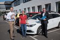 Dr. Simon Bunjamin und Elisabeth Schloten mit Landrat Hans-Jürgen Petrauschke auf einem Parkplatz mit parkenden Autos.