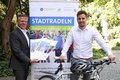 Landrat Hans-Jürgen Petrauschke und Michael Ruß mit Werbematerialien und Fahrrad