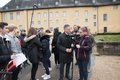 Eine Gruppe junger Menschen mit Filmausrüstung im Gespräch mit einer erwachsenen männlichen Person
