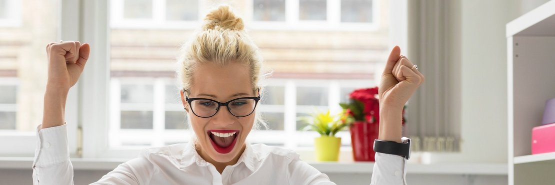 Büro Frau feiert Erfolg vor Laptop