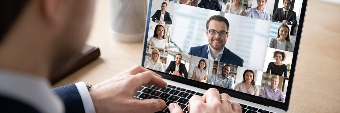 Mann sitzt vor einem Laptop mit Video-Konferenz