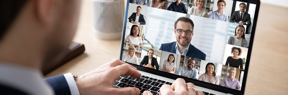 Mann sitzt vor einem Laptop mit Video-Konferenz