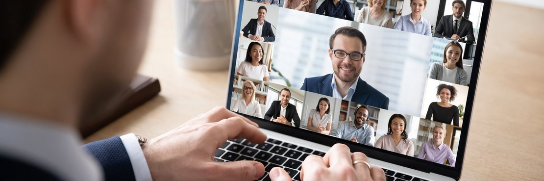 Mann sitzt vor einem Laptop mit Video-Konferenz