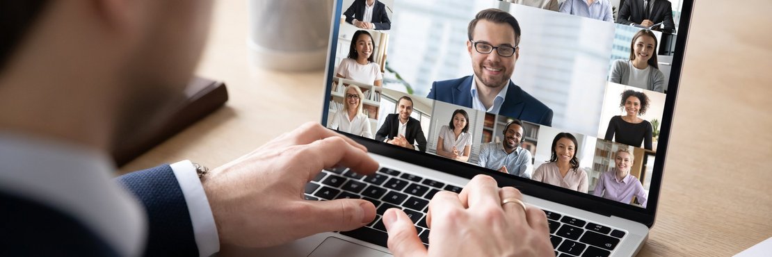 Mann sitzt vor einem Laptop mit Video-Konferenz