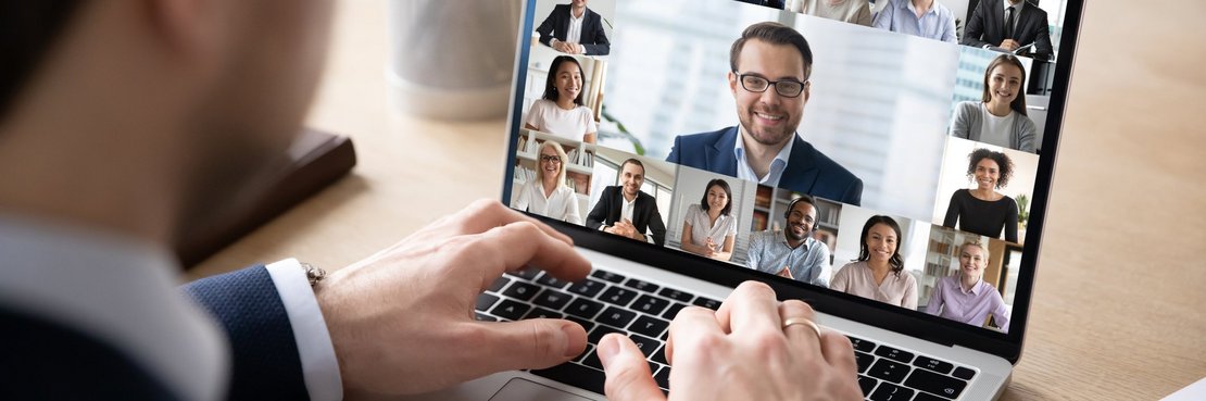 Mann sitzt vor einem Laptop mit Video-Konferenz