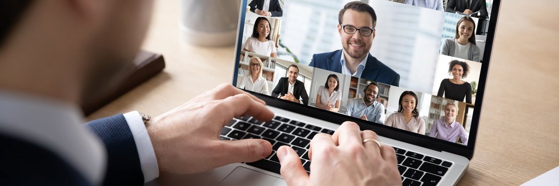 Mann sitzt vor einem Laptop mit Video-Konferenz