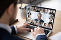 Mann sitzt vor einem Laptop mit Video-Konferenz