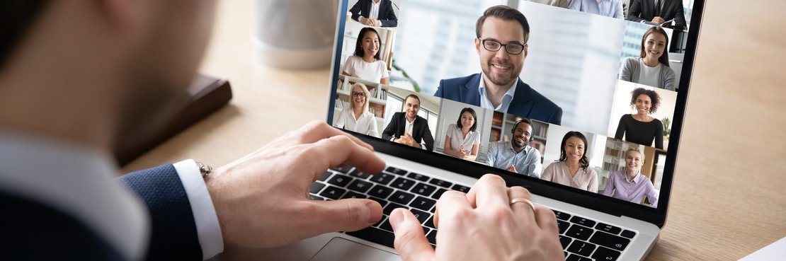 Mann sitzt vor einem Laptop mit Video-Konferenz