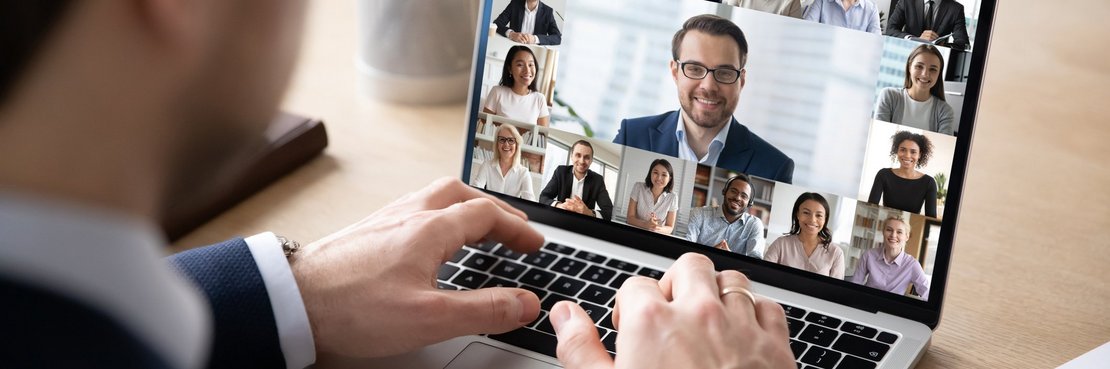 Mann sitzt vor einem Laptop mit Video-Konferenz