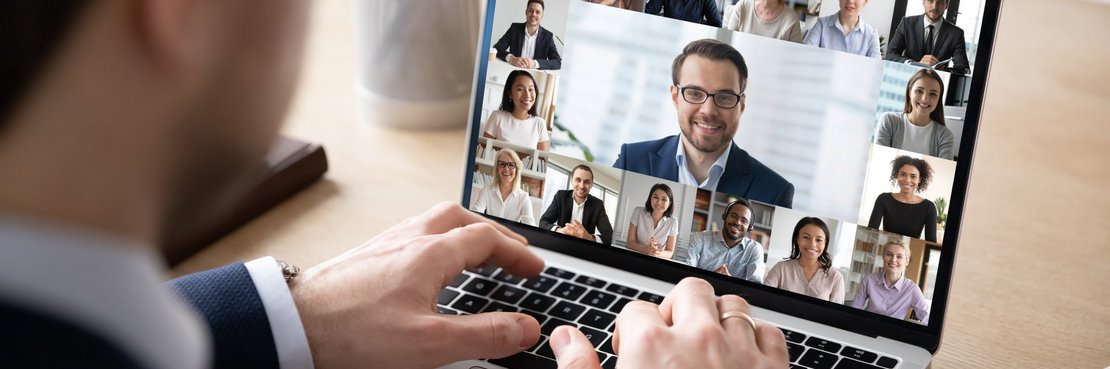 Mann sitzt vor einem Laptop mit Video-Konferenz